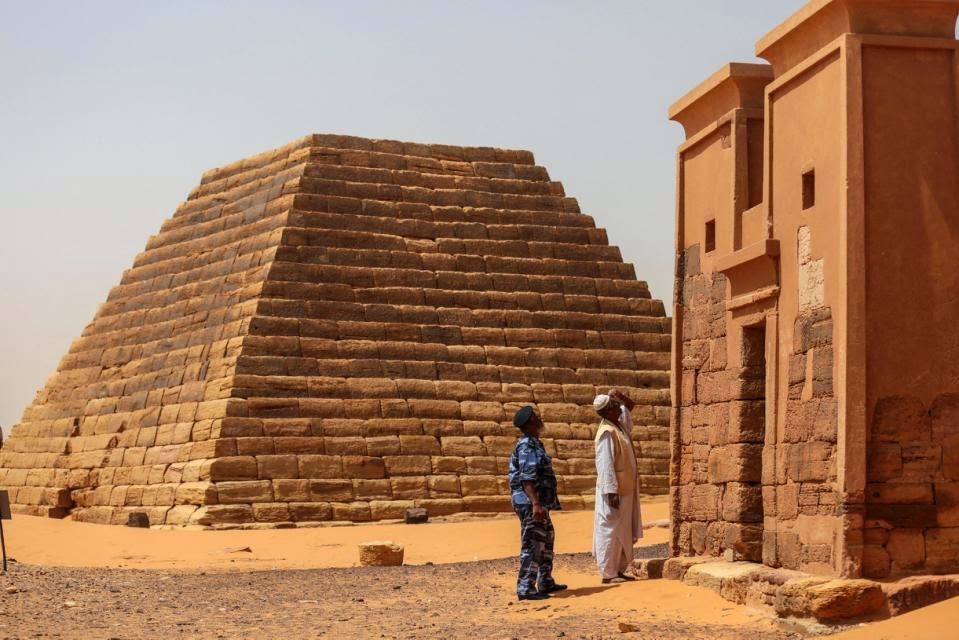 Sudanlı bir tur rehberi ve Sudanlı görevlik görevlisi, Meroe Piramitleri’ndeki bir tapınağı inceliyor. 