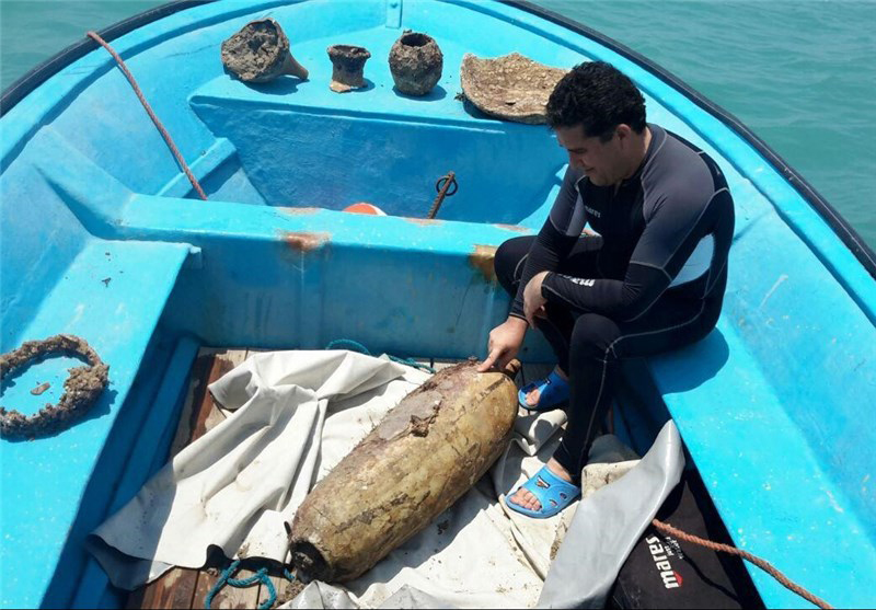 One of the diving team with a torpedo-shaped amphora believed to be from a Sassanid era shipwreck in the shallow waters of the Bushehr Peninsula. 